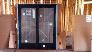 A sliding glass door waiting to be installed. Black exterior finish with pine Mocha color interior stain.