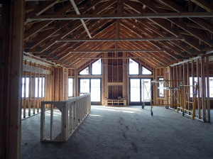 View of the main living area from just inside the front door. Kitchen to the left, Living and Dining Rooms to the right. Covered deck through the sliders with fireplace between.