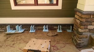 Installing sill stones on the road side of the home.